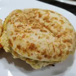 Pão de queijo recheado e prensado.