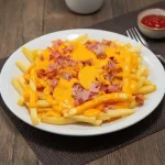 Papas fritas con cheddar y panceta
