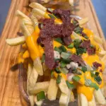 Papas con cheddar, verdeo y panceta